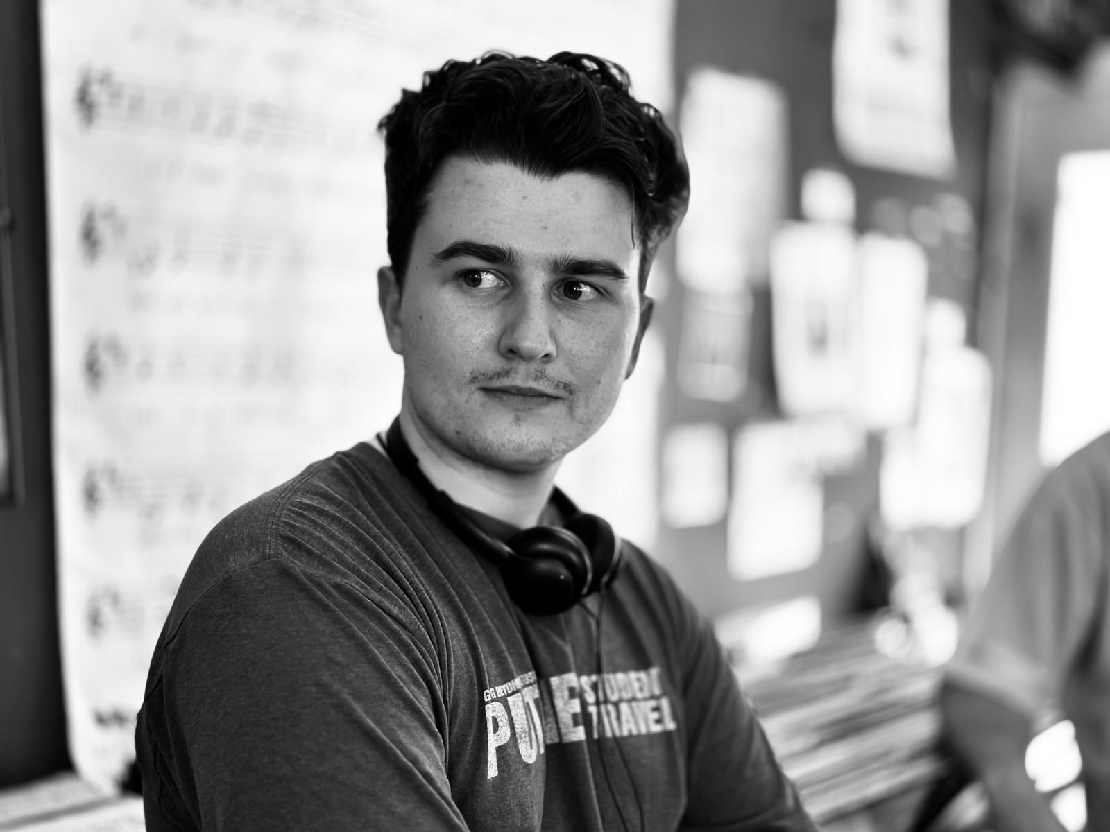 Black-and-white portrait of writer-director Wes Clark with headphones around his neck